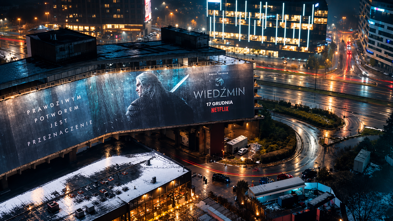 Mural promujący serial Wiedźmin na budynku w nocnym mieście